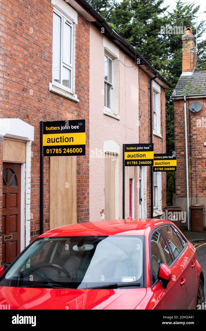 House for auction signs in a UK street. 3 homes ready to go under the hammer Stock Photo