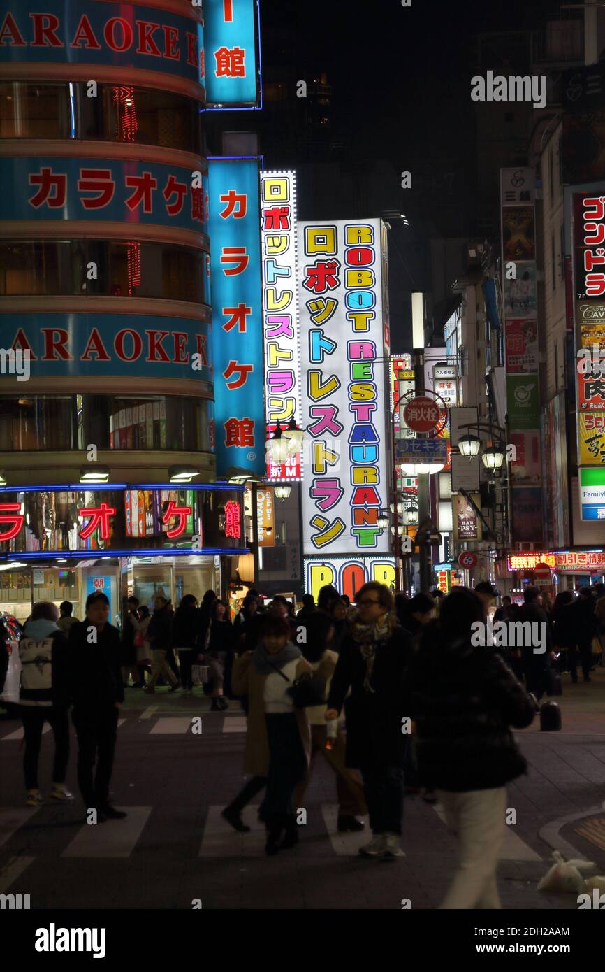 Crowds enjoying the night life under the neon lights of the Tokyo red light area in Shinjuku Kabukicho district. Stock Photo