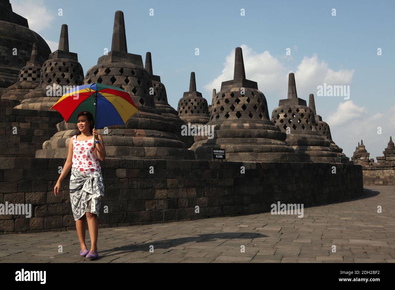 Young visitor with an umbrella in the Borobudur Temle in Central Java, Indonesia. Stock Photo