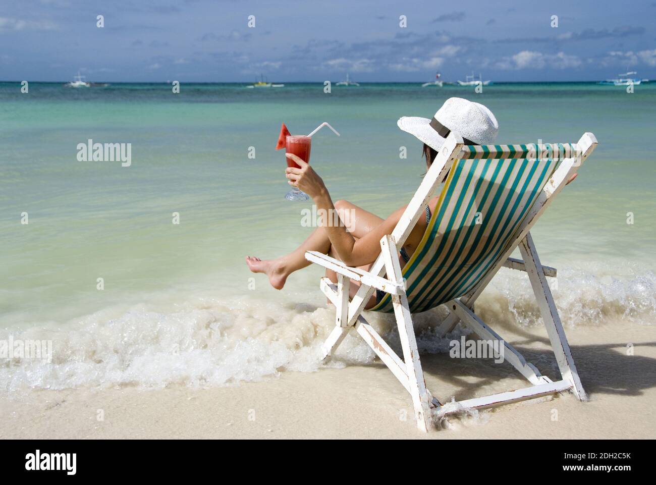 Frau auf Soinnenstuhl sitzt am Strand und geniesst einen Cocktail, Philippinen, Insel Boracay, MR: Yes Stock Photo