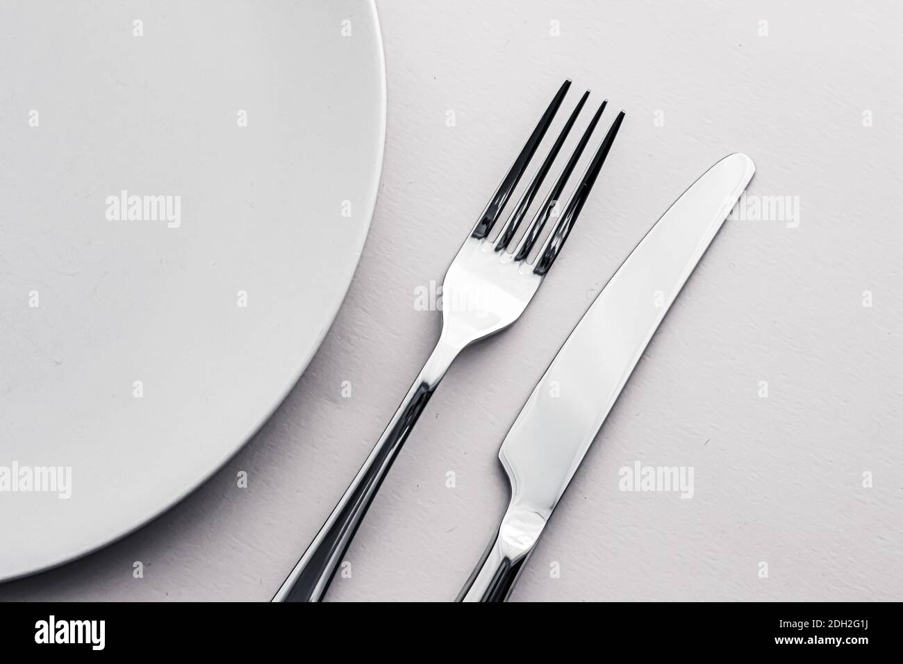 Empty plate and cutlery as mockup set on white background, top ...
