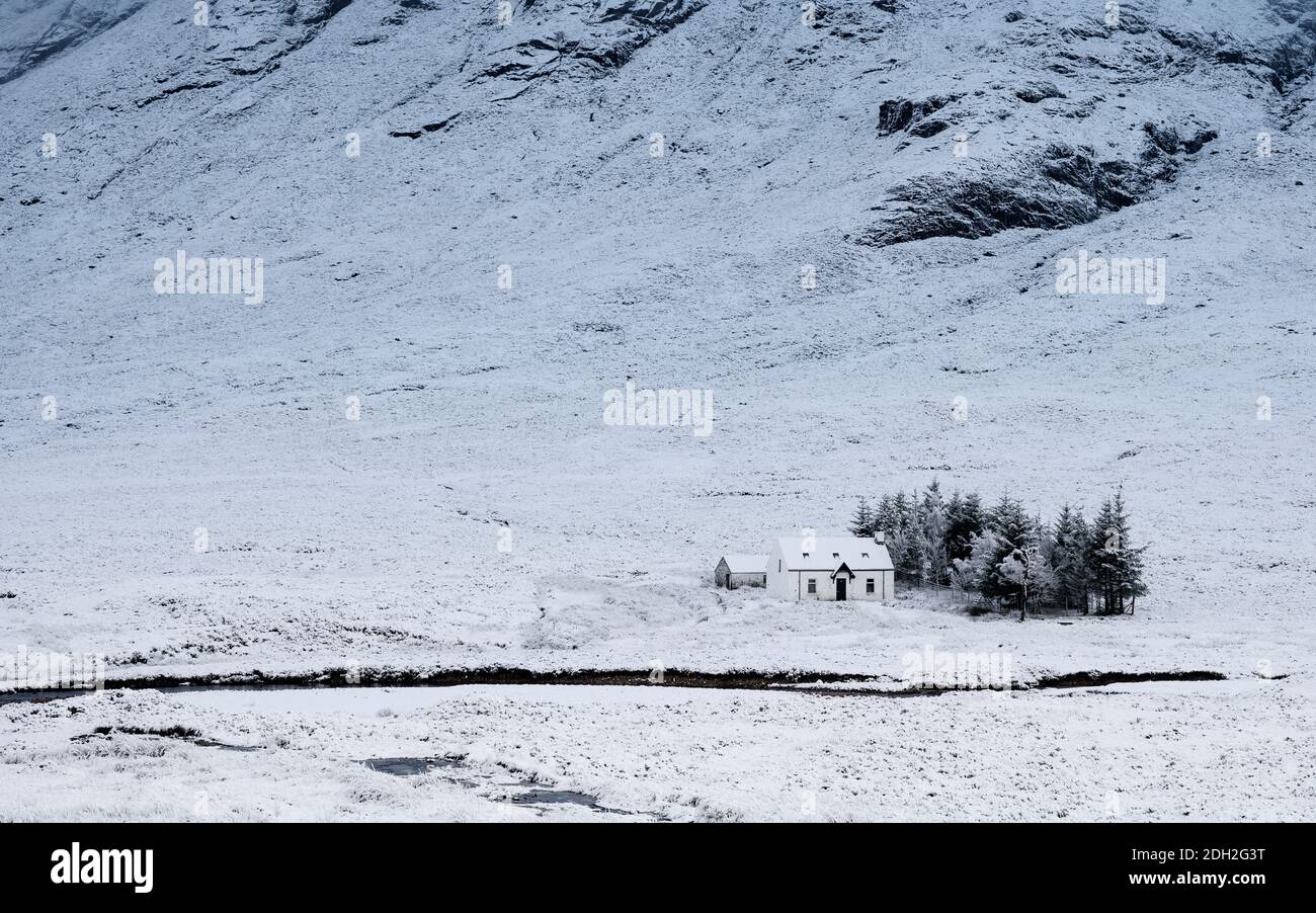 Winter snow  scene of cottage at base of Buachaille Etive Mor mountain near Glen Coe in Scotland, UK Stock Photo