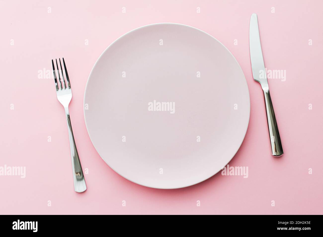 Empty plate and cutlery as mockup set on pink background, top tableware ...