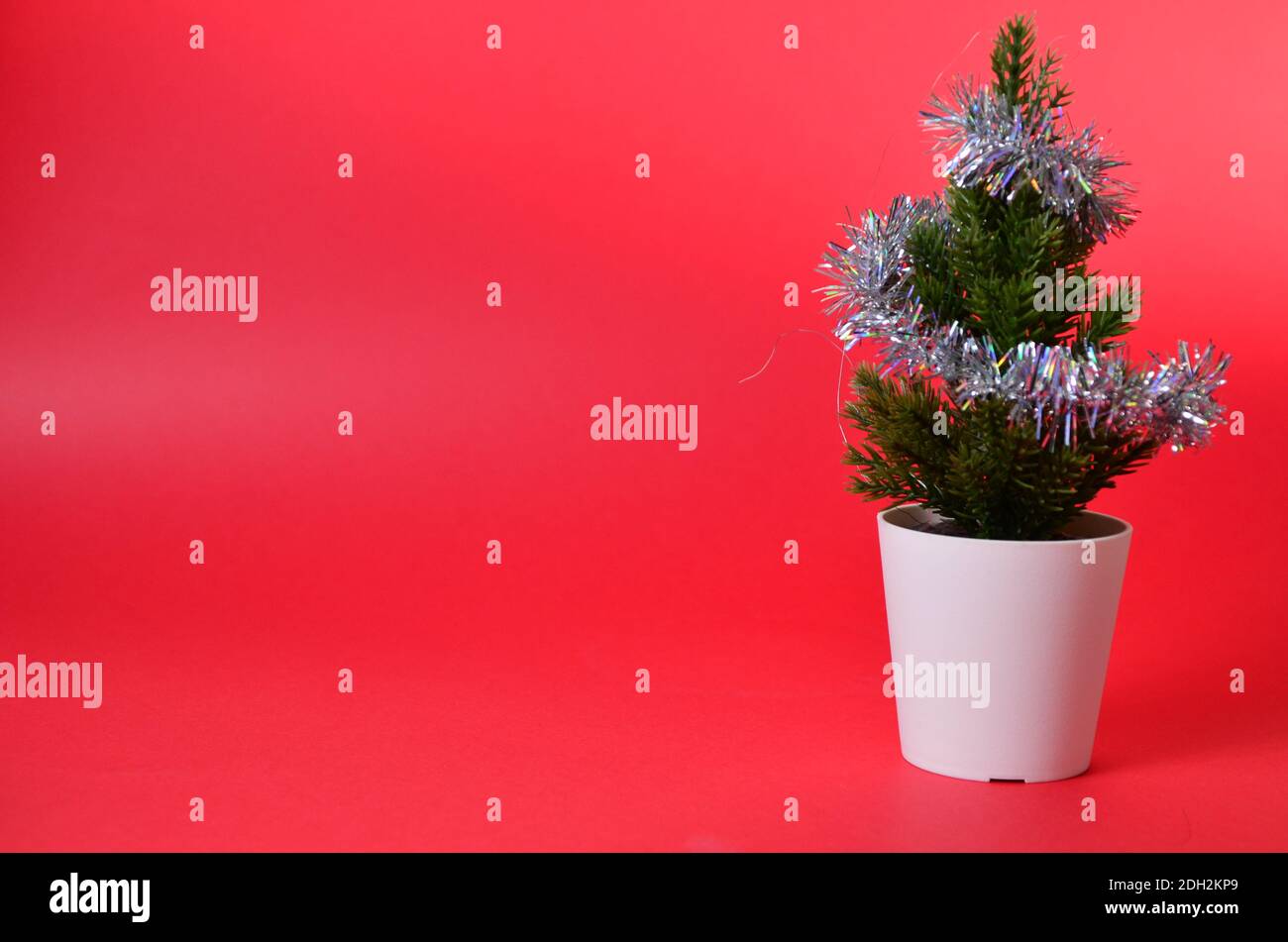 small Christmas tree decorations on red. Branches of a Christmas tree