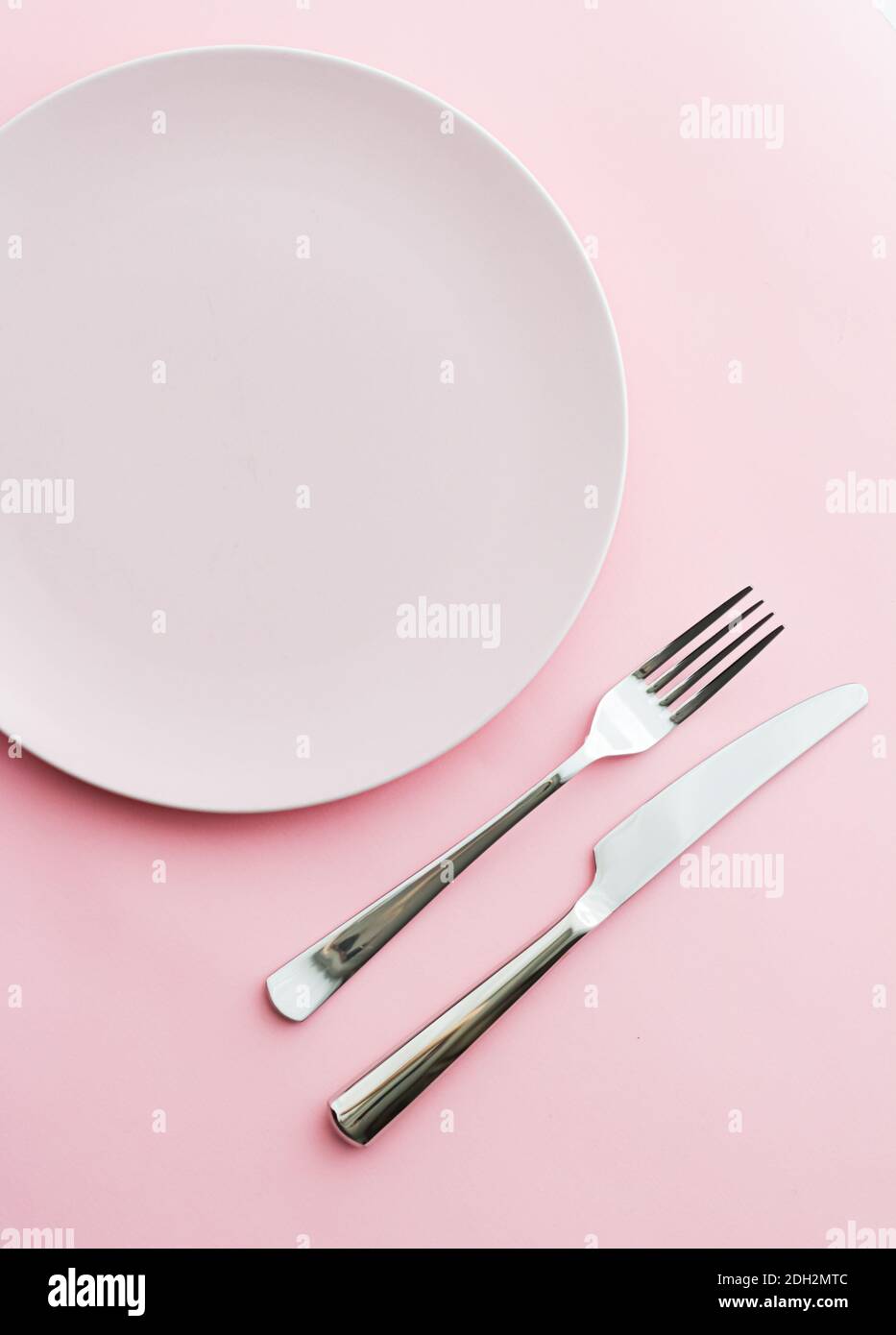 Empty plate and cutlery as mockup set on pink background, top tableware ...