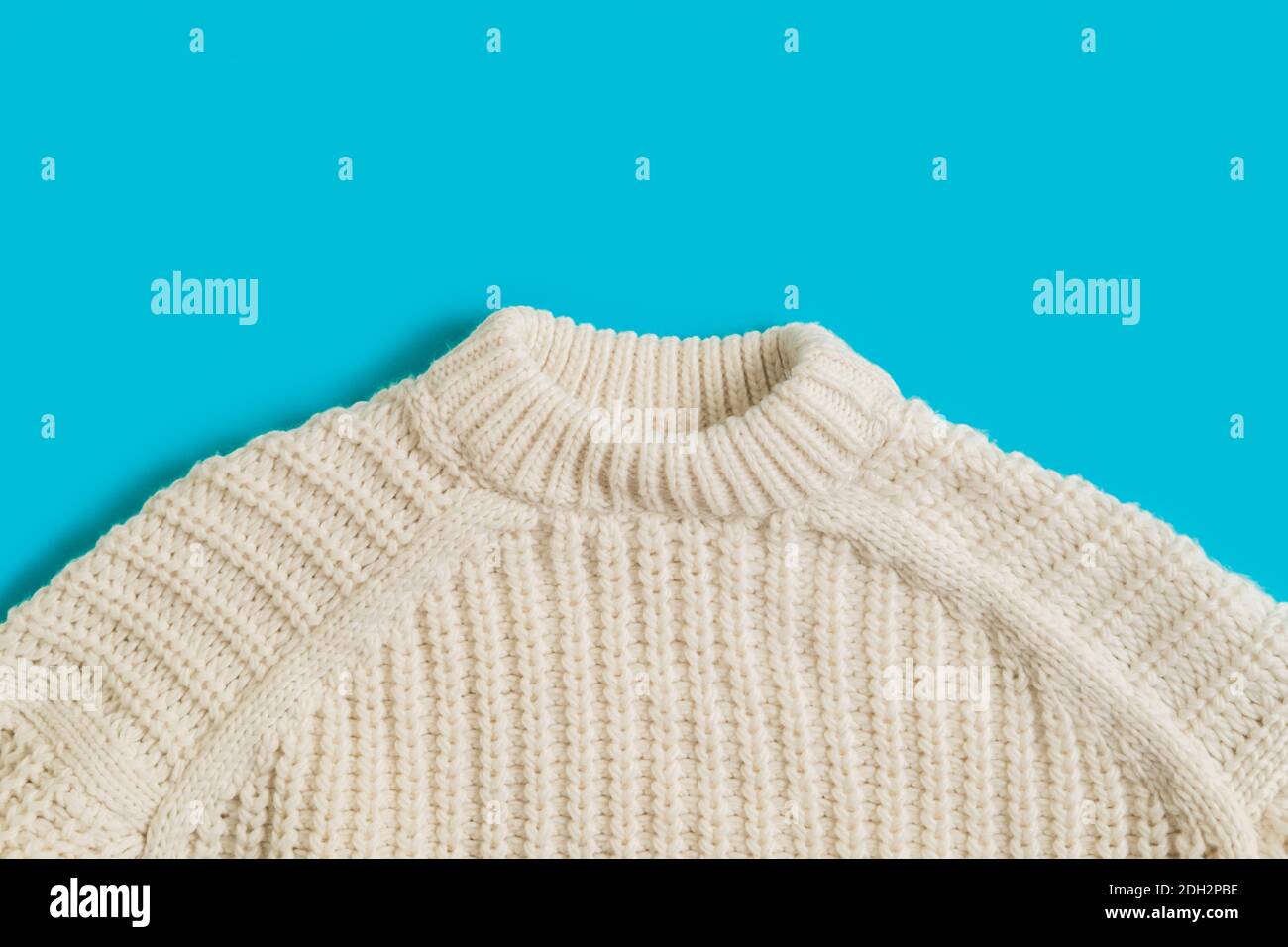 Woolen knitted patterned sweater fabric textile texture on a bright blue background Stock Photo