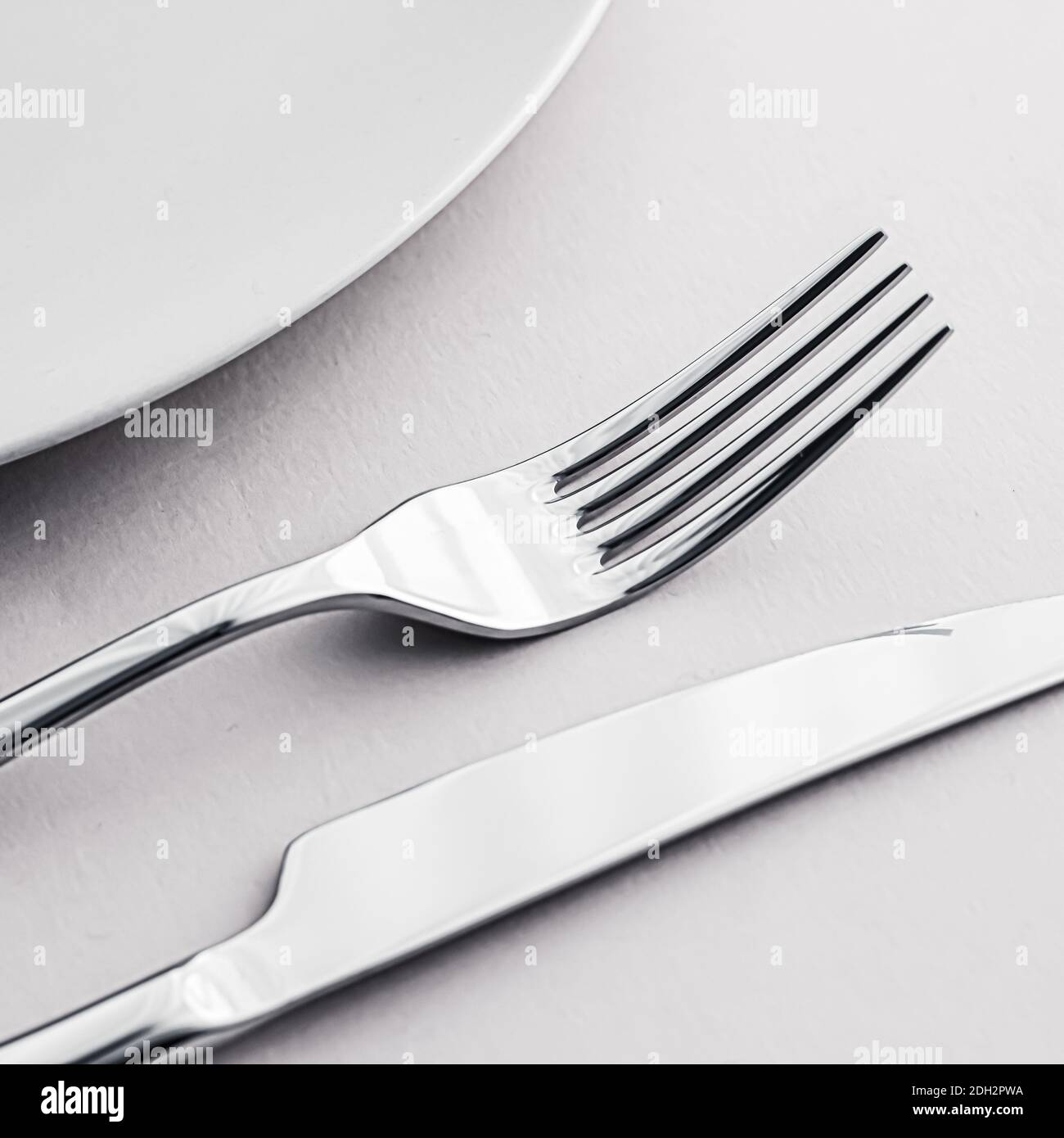 Empty plate and cutlery as mockup set on white background, top ...