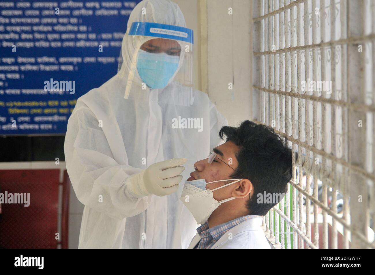 A medical officer wearing a protective kit is collecting samples for