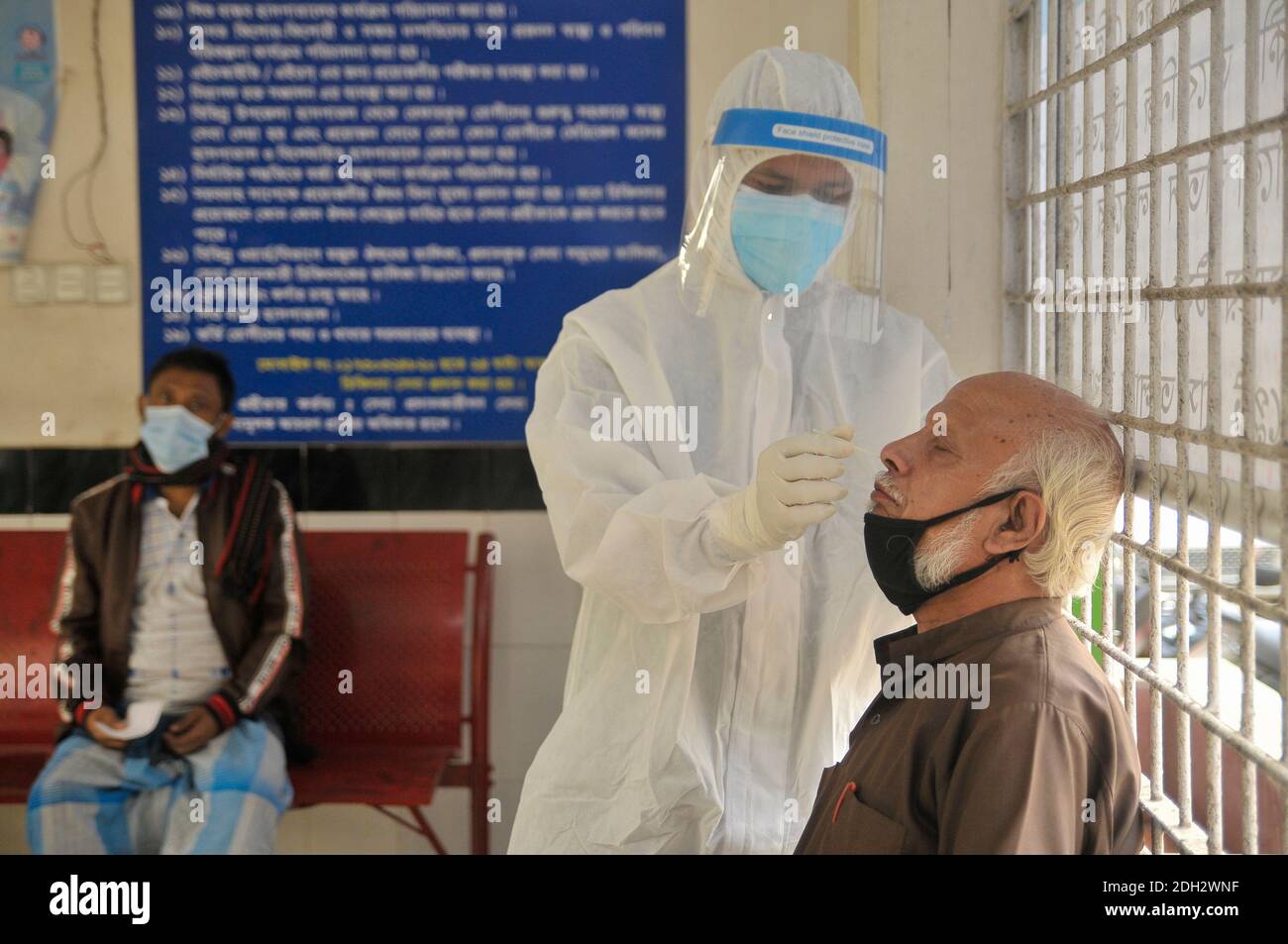 A medical officer wearing a protective kit is collecting samples for