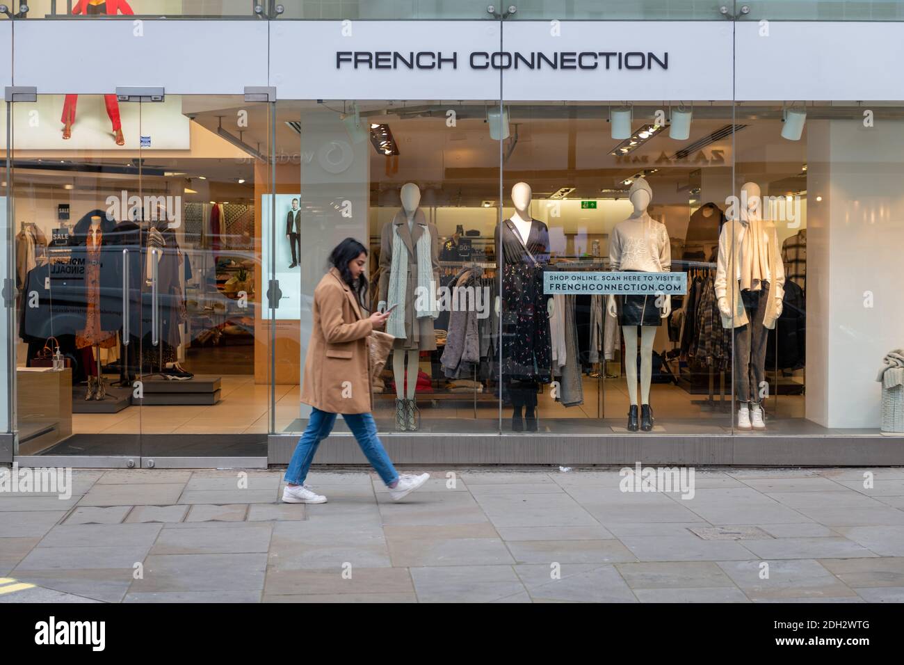 A pedestrian walking pass a branch of the fashion retailer French Connection. Stock Photo