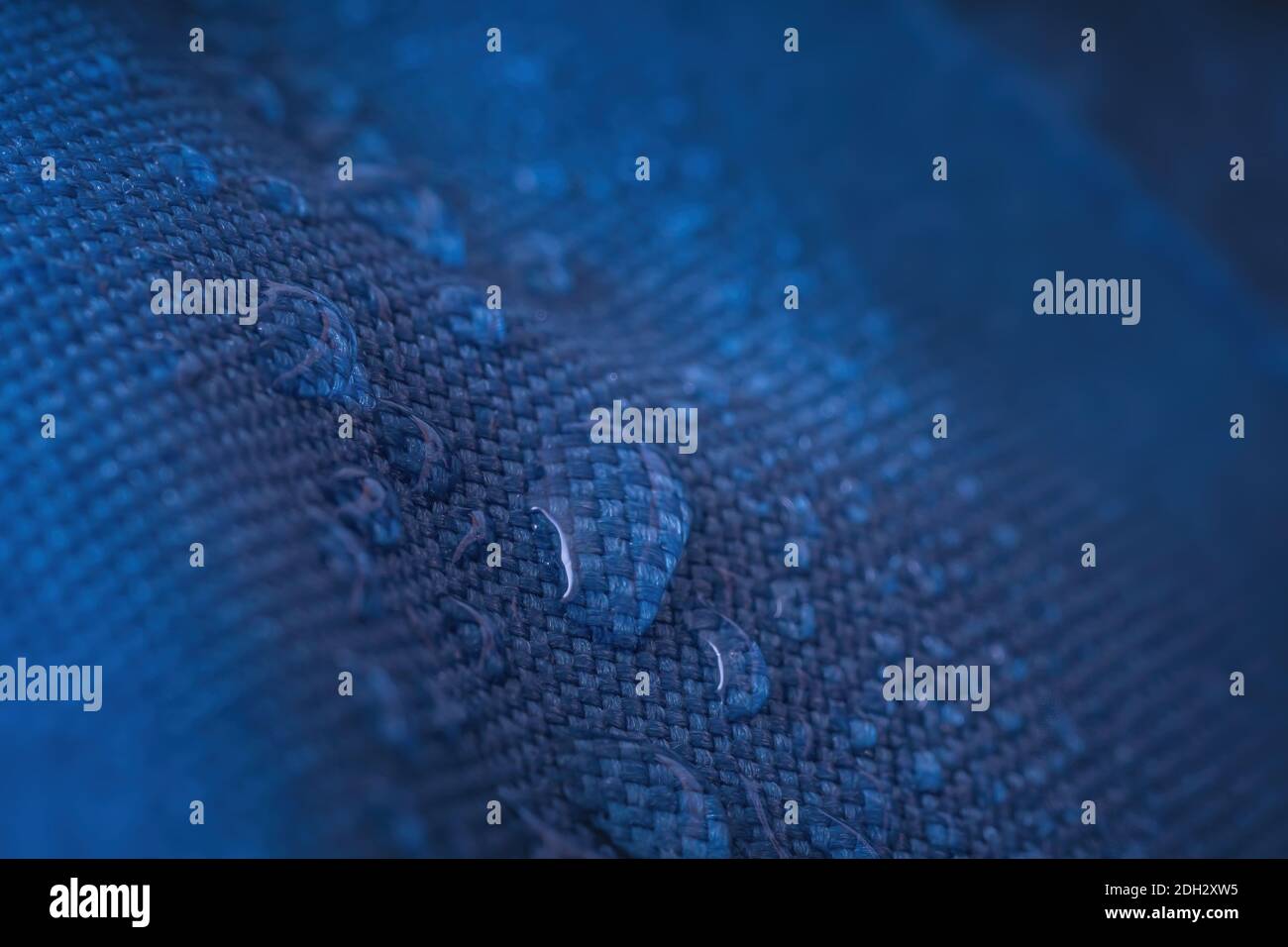 Water drops on waterproof impregnated blue fabric. Stock Photo