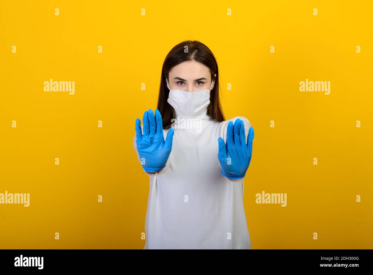 Girl in medical gloves dress protective mask on her face on studio ...