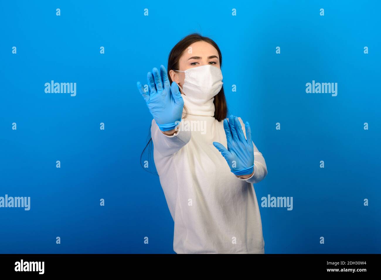 Girl in medical gloves dress protective mask on her face on studio ...