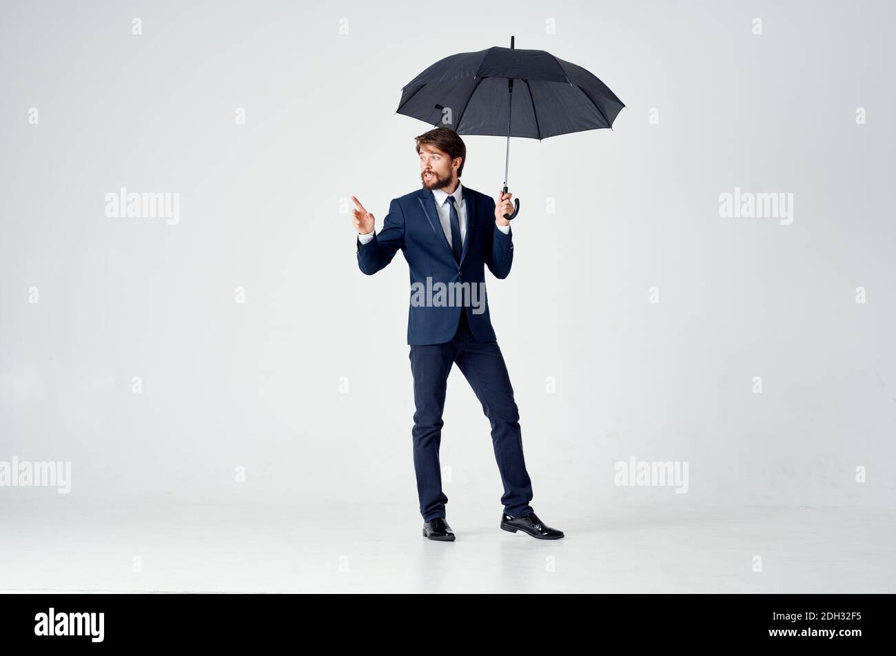 elegant gentleman with a dark umbrella on a light background and a