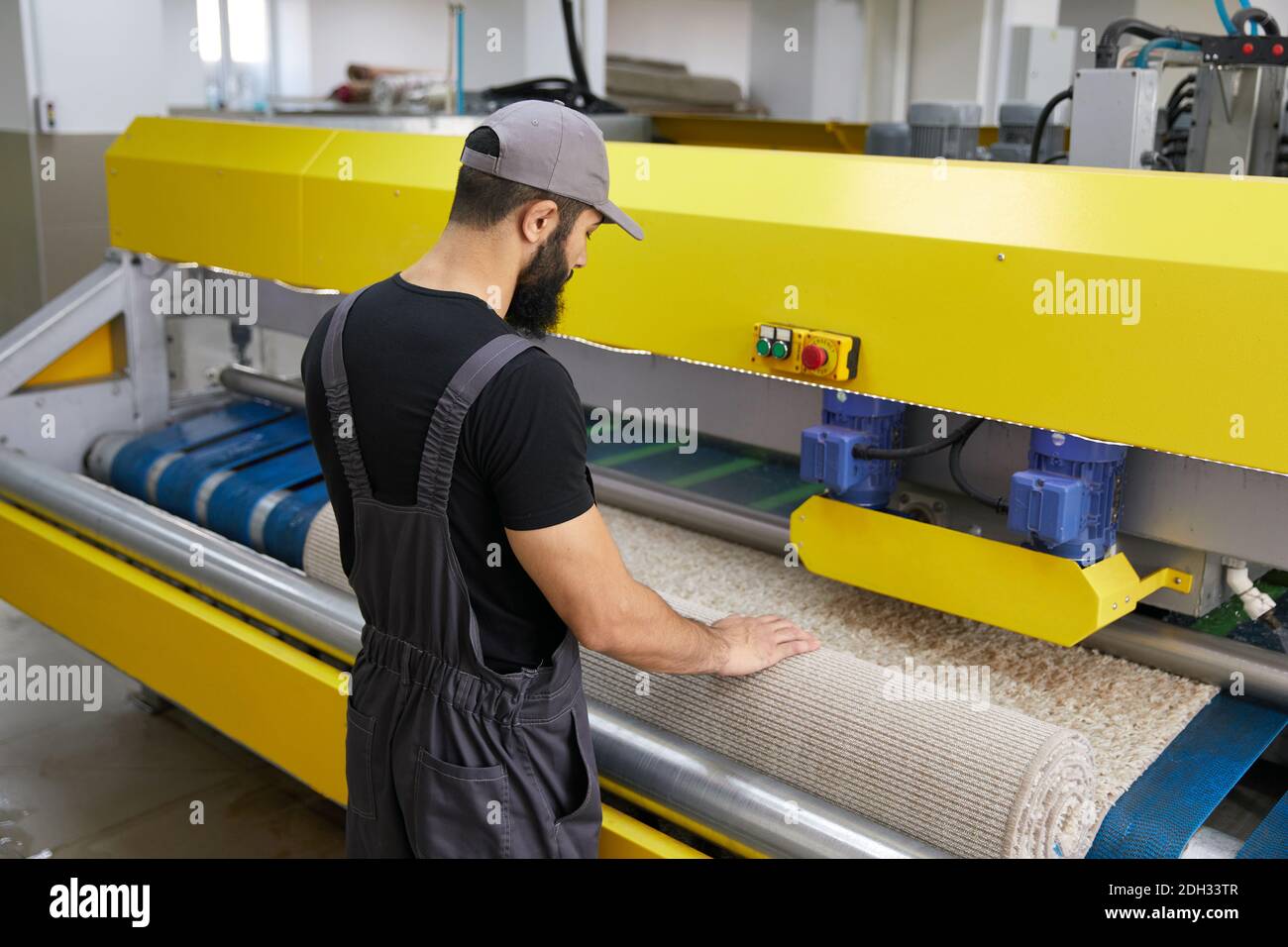 Man operating carpet automatic washing machine in professional laundry service Stock Photo