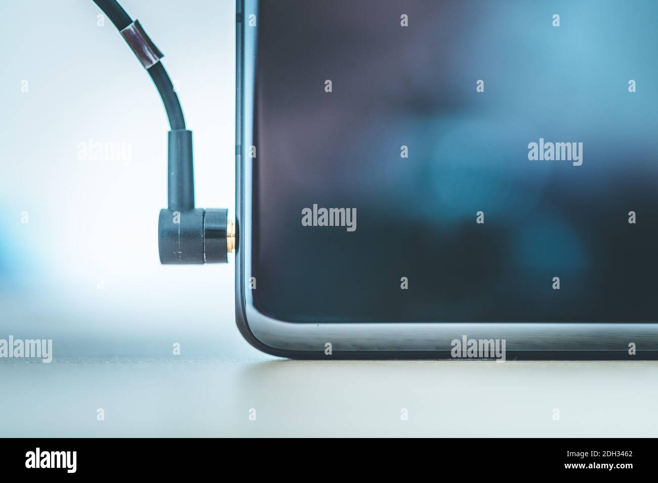 Audio jack concept Connecting audio jack to a black mobile phone