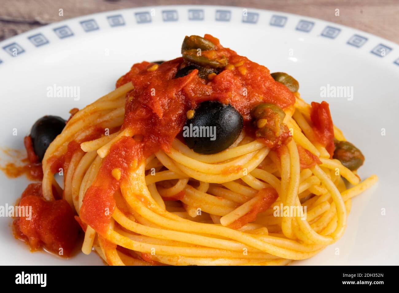 Spaghetti alla Puttanesca, with tomato, olives, capers and anchovies Stock Photo