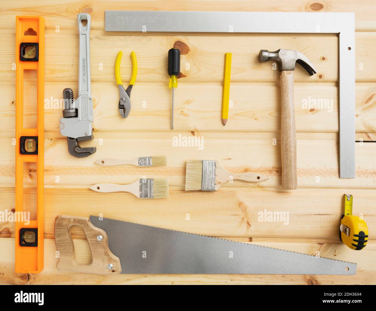 Tools arranged on a wooden surface for DIY projects, including a hammer ...