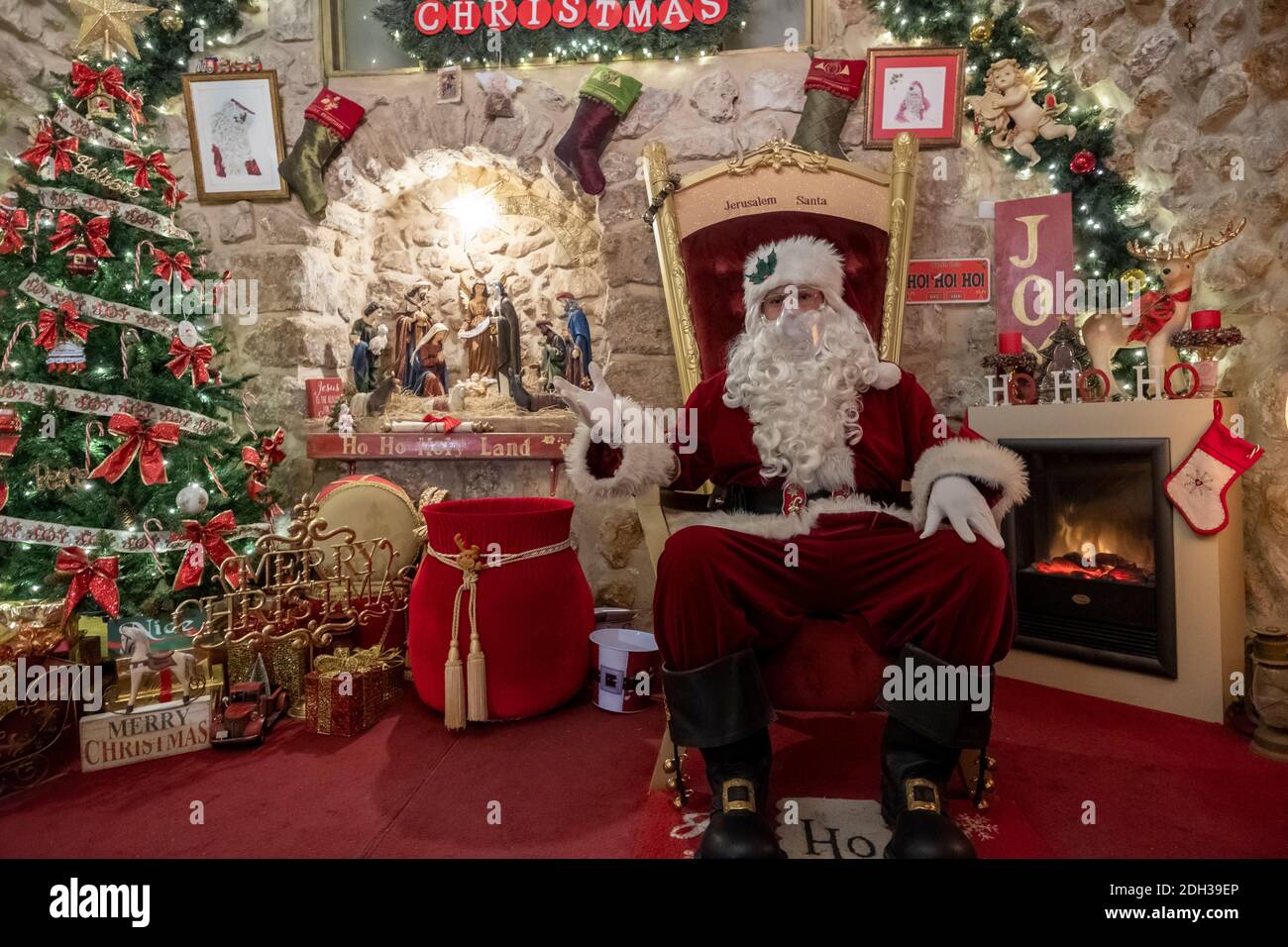 Issa Kassissieh an Arab Orthodox Christian and Israel’s only certified Santa Claus sits at his Santa's House decorated for Christmas in the Christian Quarter old city of Jerusalem Israel Stock Photo