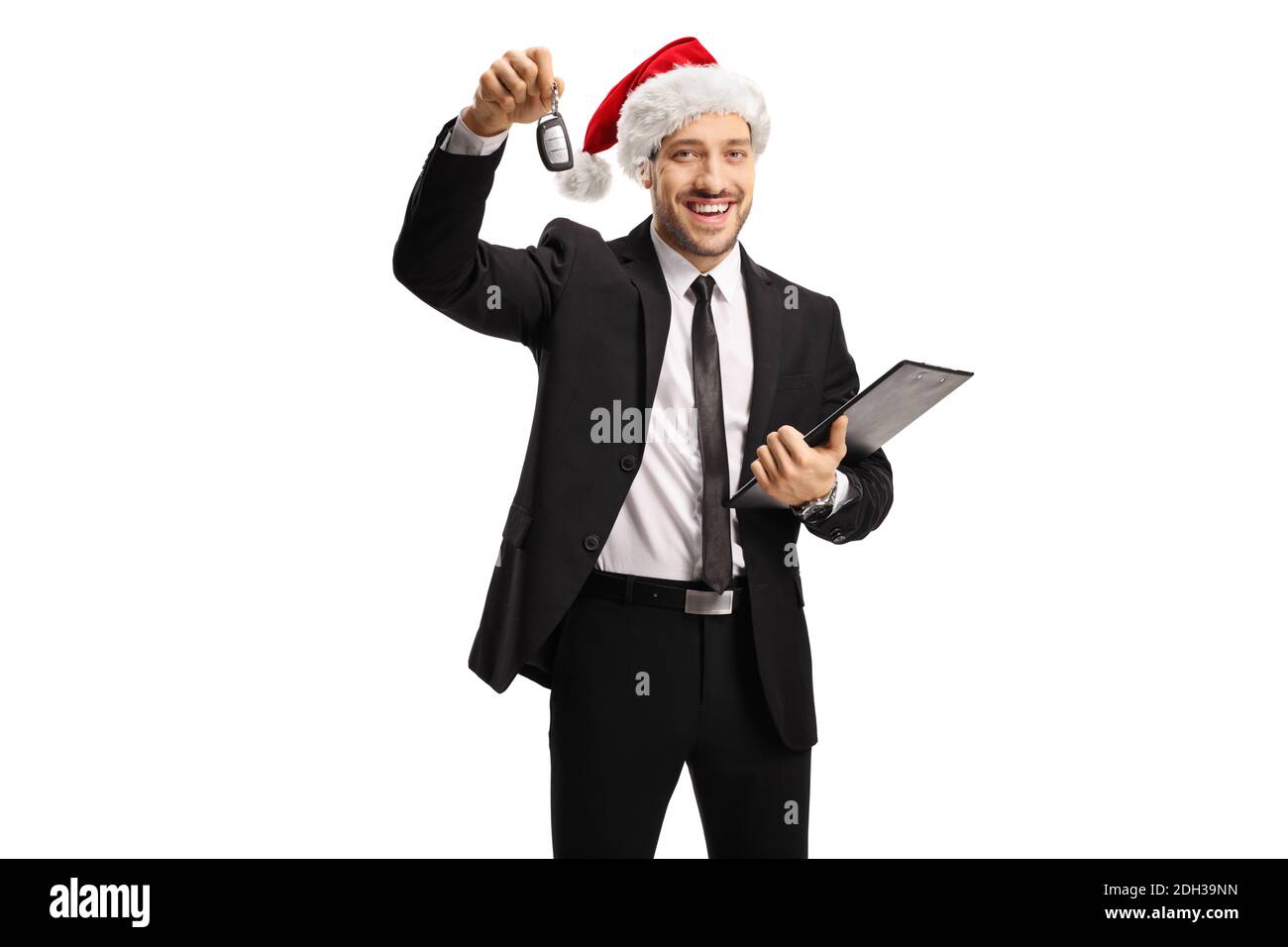 Smiling man in a suit showing a car key and wearing a santa claus hat isolated on white background Stock Photo