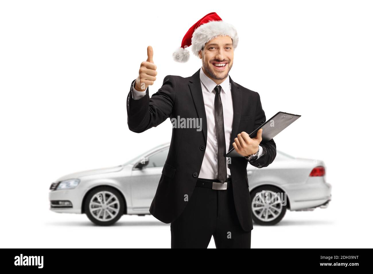 Man with a silver car wearing a christmas santa claus hat and showing thumbs up isolated on white background Stock Photo