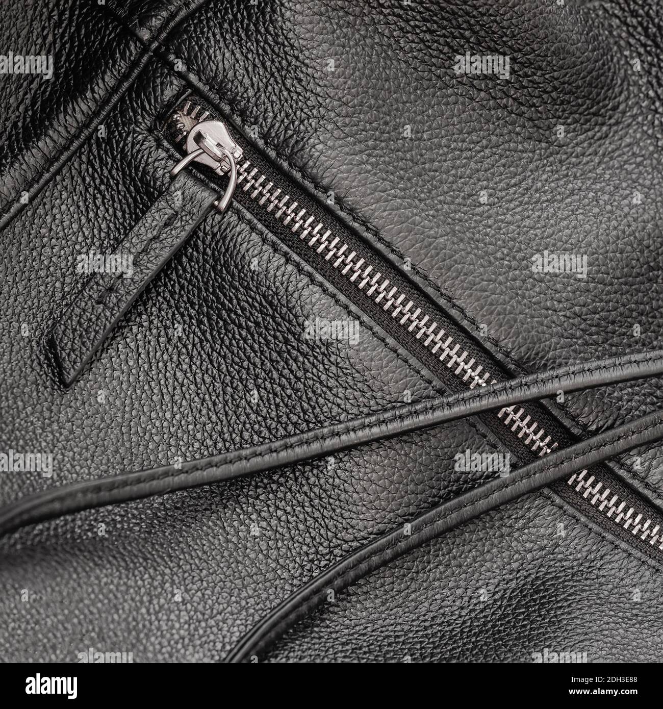Detail of black leather handbag with zipper and black strap close up, background, texture Stock Photo