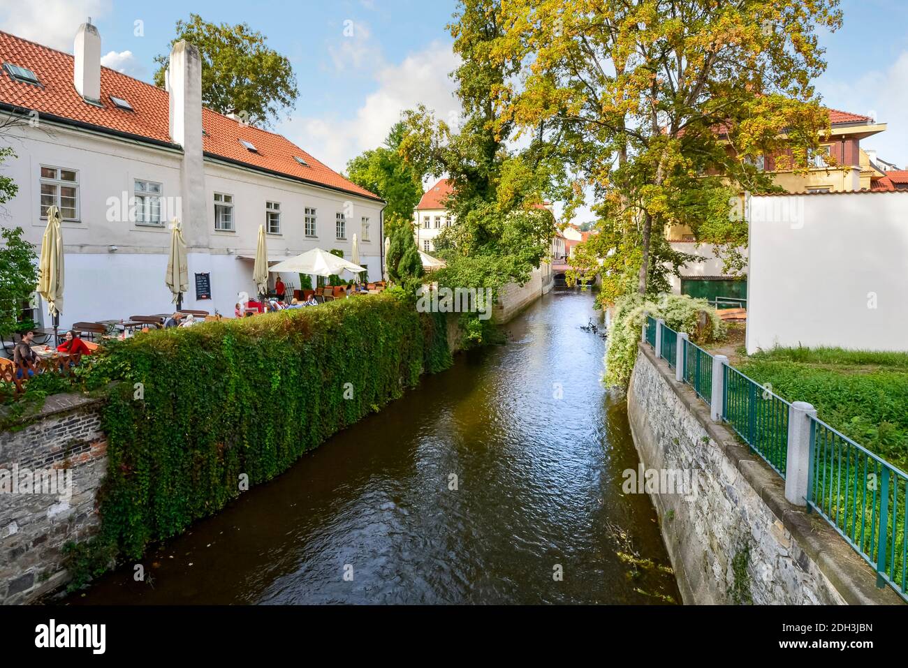 Tourists and locals eat lunch at an outdoor cafe alongside a canal just off the river Vltava in the scenic area of Kampa Island in Prague, Czech Repub Stock Photo
