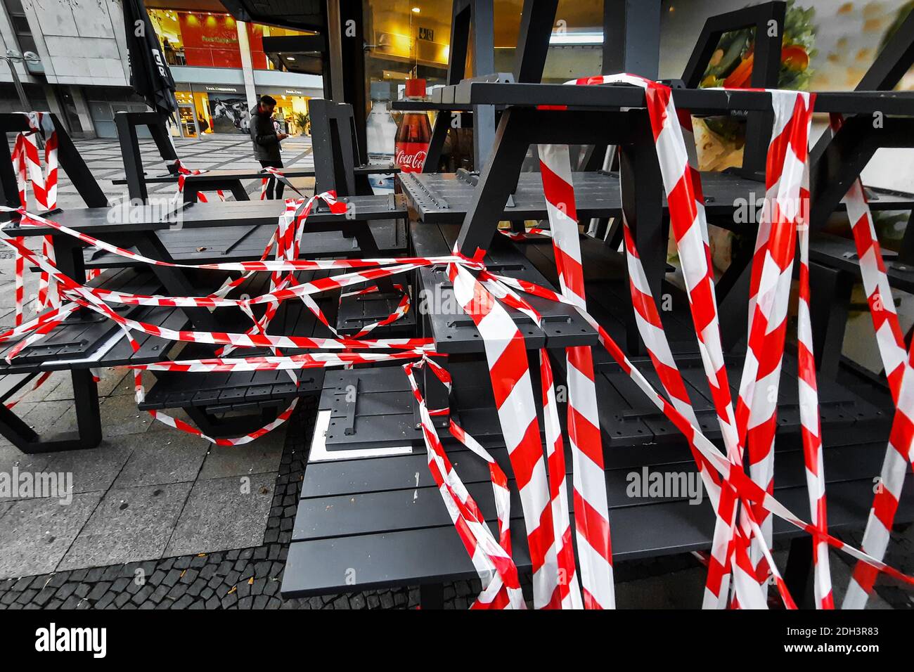 Dortmund, 09.12.2020 - Im Außenbereich eines Backshops sind Tische und Bänke mit rot-weißem Flatterband abgesperrt. Restaurants und Cafés dürfen aufgrund von Corona-Verordnungen nur noch Speisen zum Mitnehmen anbieten. Stock Photo