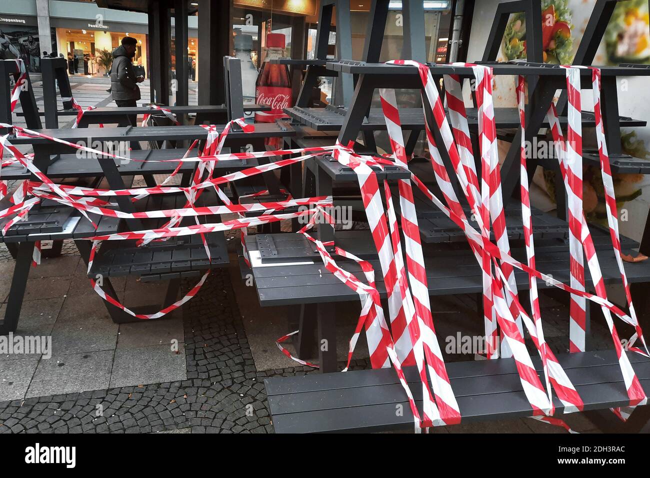 Dortmund, 09.12.2020 - Im Außenbereich eines Backshops sind Tische und Bänke mit rot-weißem Flatterband abgesperrt. Restaurants und Cafés dürfen aufgrund von Corona-Verordnungen nur noch Speisen zum Mitnehmen anbieten. Stock Photo