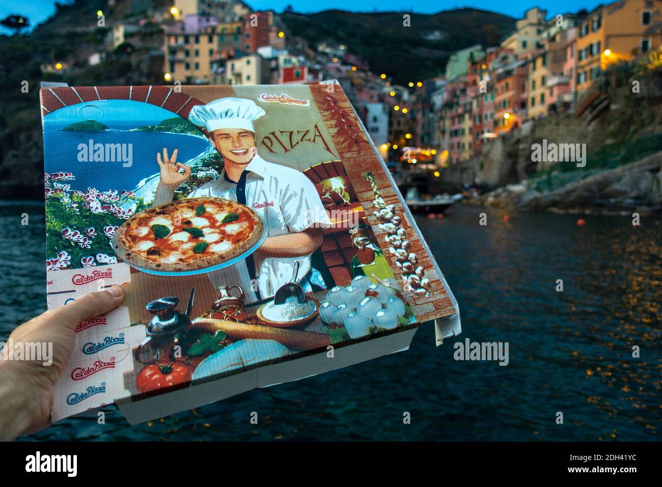 Hand holding a pizza box in Riomaggiore, Italy, Pizza in Cinque Terre wallpaper Stock Photo