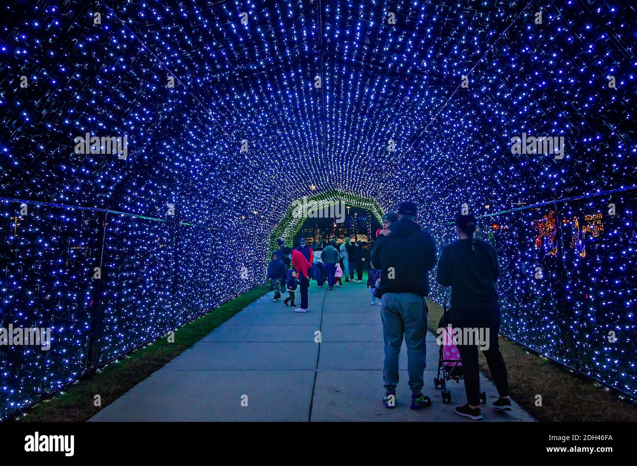 People walk through a LED Christmas lights tunnel during a holiday