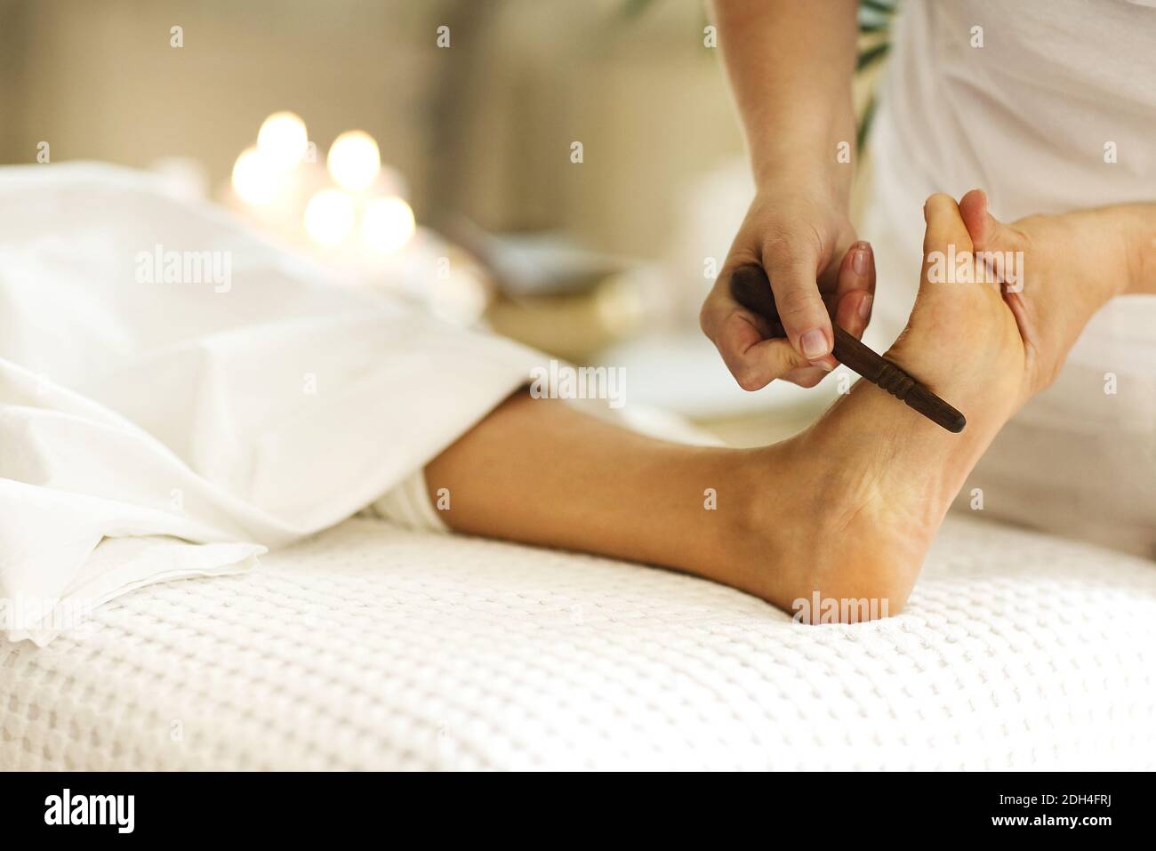 Crop masseuse making feet massage to client Stock Photo