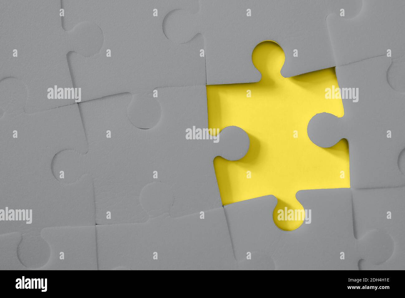 Multiple grey puzzle pieces put together without one piece on yellow background. Colors of year 2021. Place for text. Stock Photo