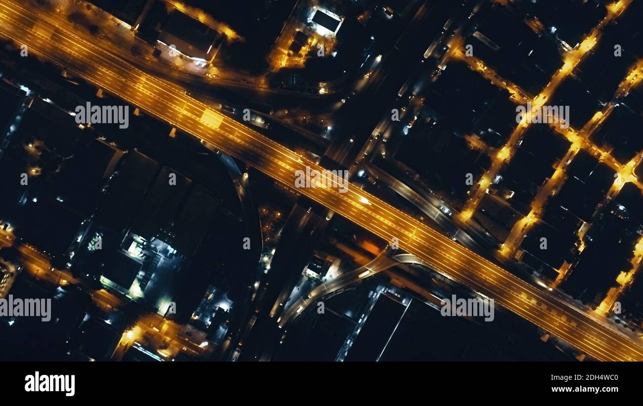 Top down night traffic highway with illuminated city streets aerial. Philippines downtown cityscape with modern architecture of skyscrapers buildings. Cinematic urban road at lantern lights drone shot Stock Photo