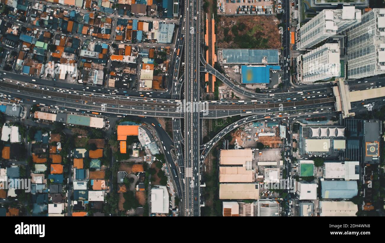 Top down of traffic cross highway at downtown aerial. Skyscrapers, buildings roofs of Philippines capital city of Manila cityscape. Scenic urban transportation: cars, buses at town road Stock Photo