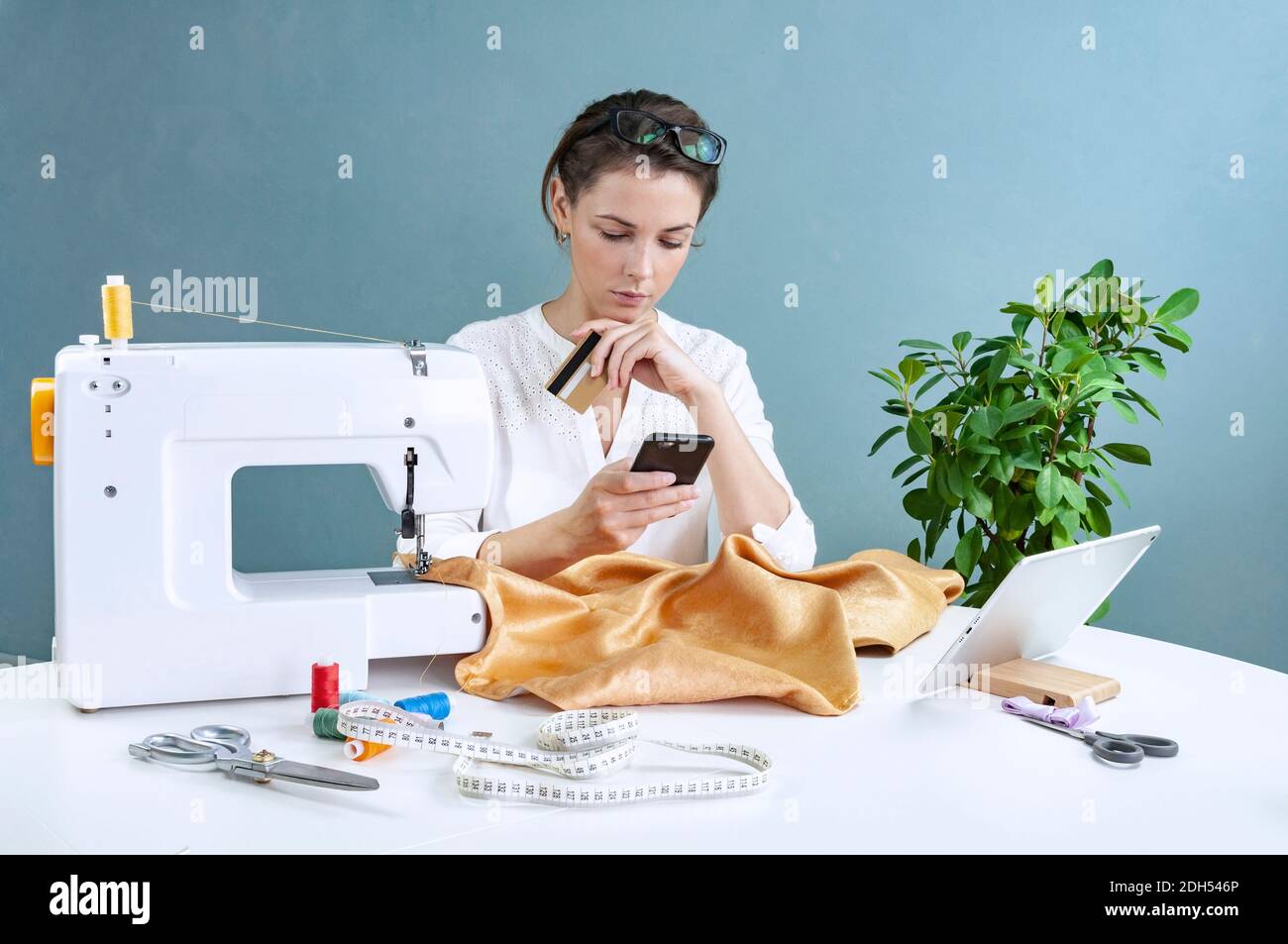 Woman Seamstress Sitting And Sews On Sewing Machine Dressmaker