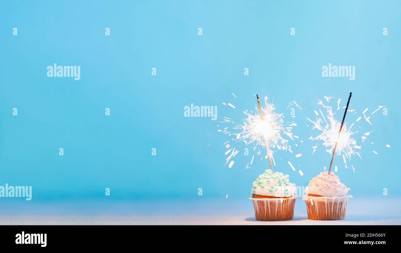 Two cupcakes decorated with sparklers, copy space Stock Photo