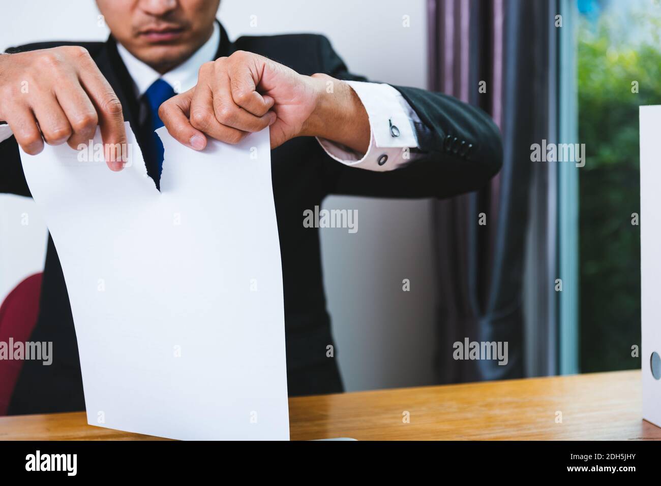 Business man angry breaking tearing paper document on desk office Stock Photo