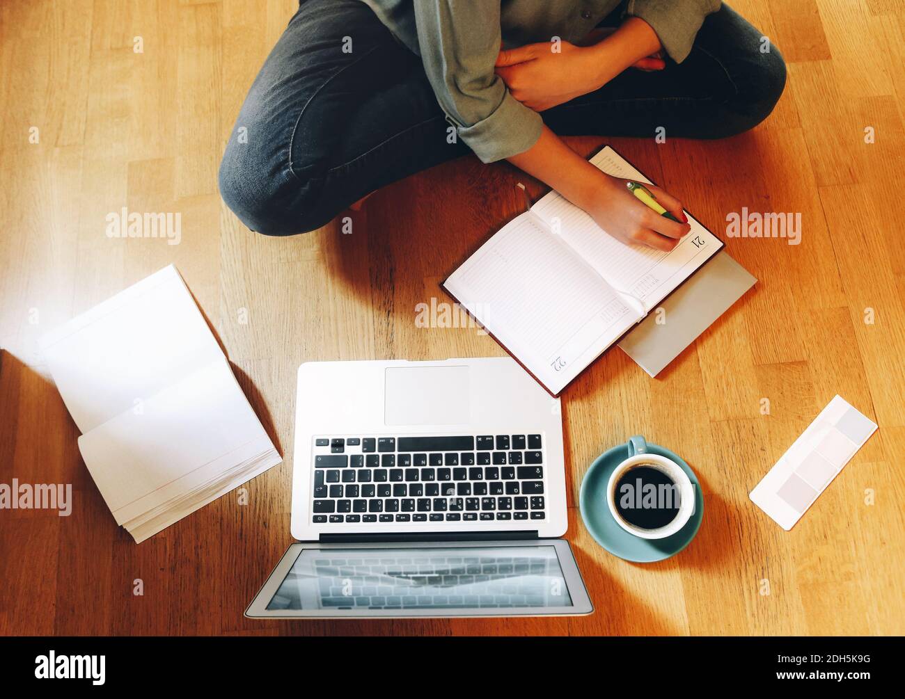 Crop designer using laptop on floor Stock Photo