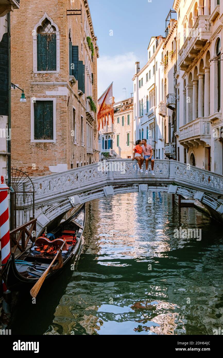 Couple men and woman on a city trip to Venice Italy, colorful streets with canals Venice Stock Photo