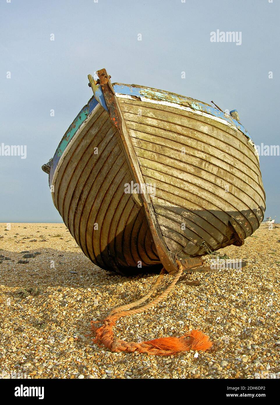 The hull of an old fishing boat left high and dry on the shingle beach ...