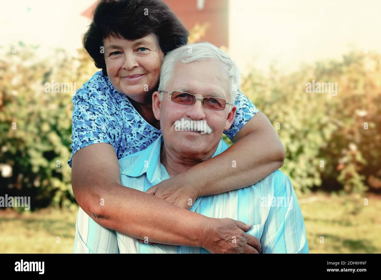 Loving mature cople hugs on a summer day in the park.Senior couple are sitting outdoors.An elderly woman hugs an old man Stock Photo