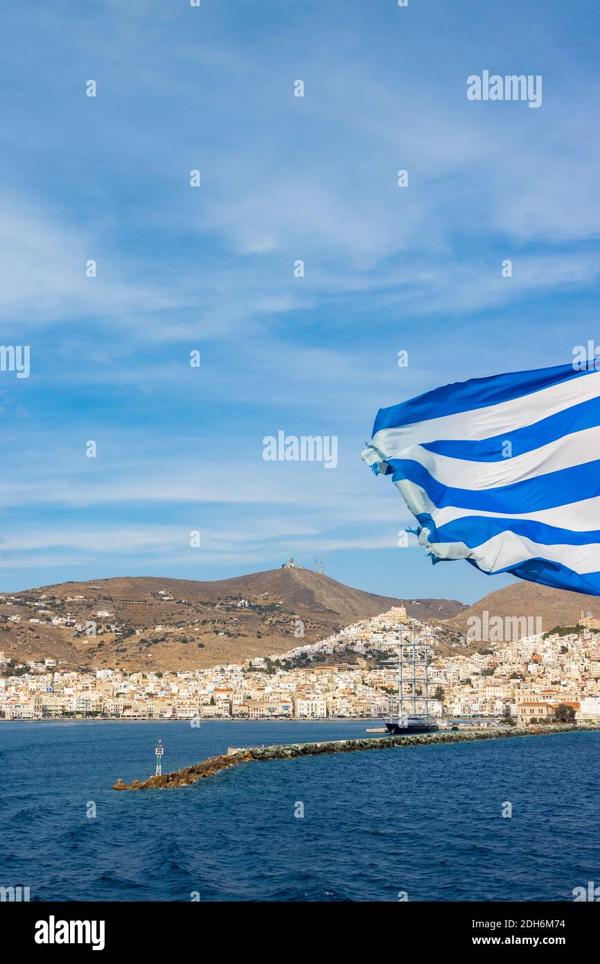 Greek flag in front of the port of the Cycladic island of Syros Stock Photo