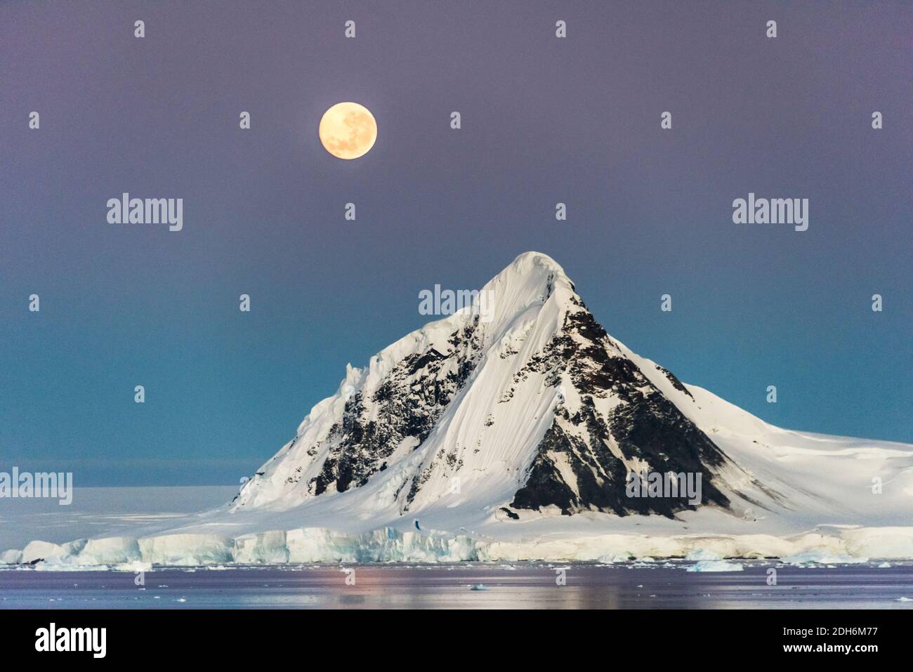Moon over snow covered island in South Atlantic Ocean, Antarctica Stock Photo