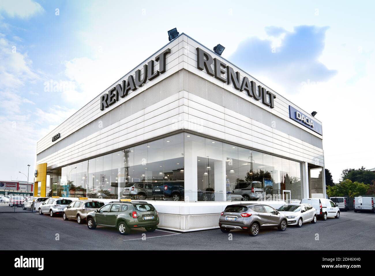 Corner of Renault and Dacia car dealer office building with several cars parked outside the showroom, viewed from low angle with wide angle camera Stock Photo