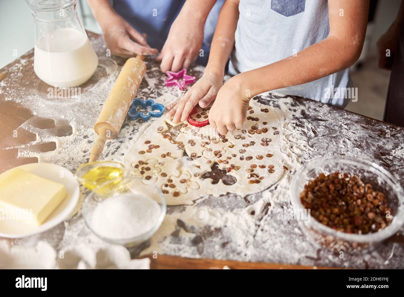 Kids covered in flour making cookie shapes out of dough Stock Photo