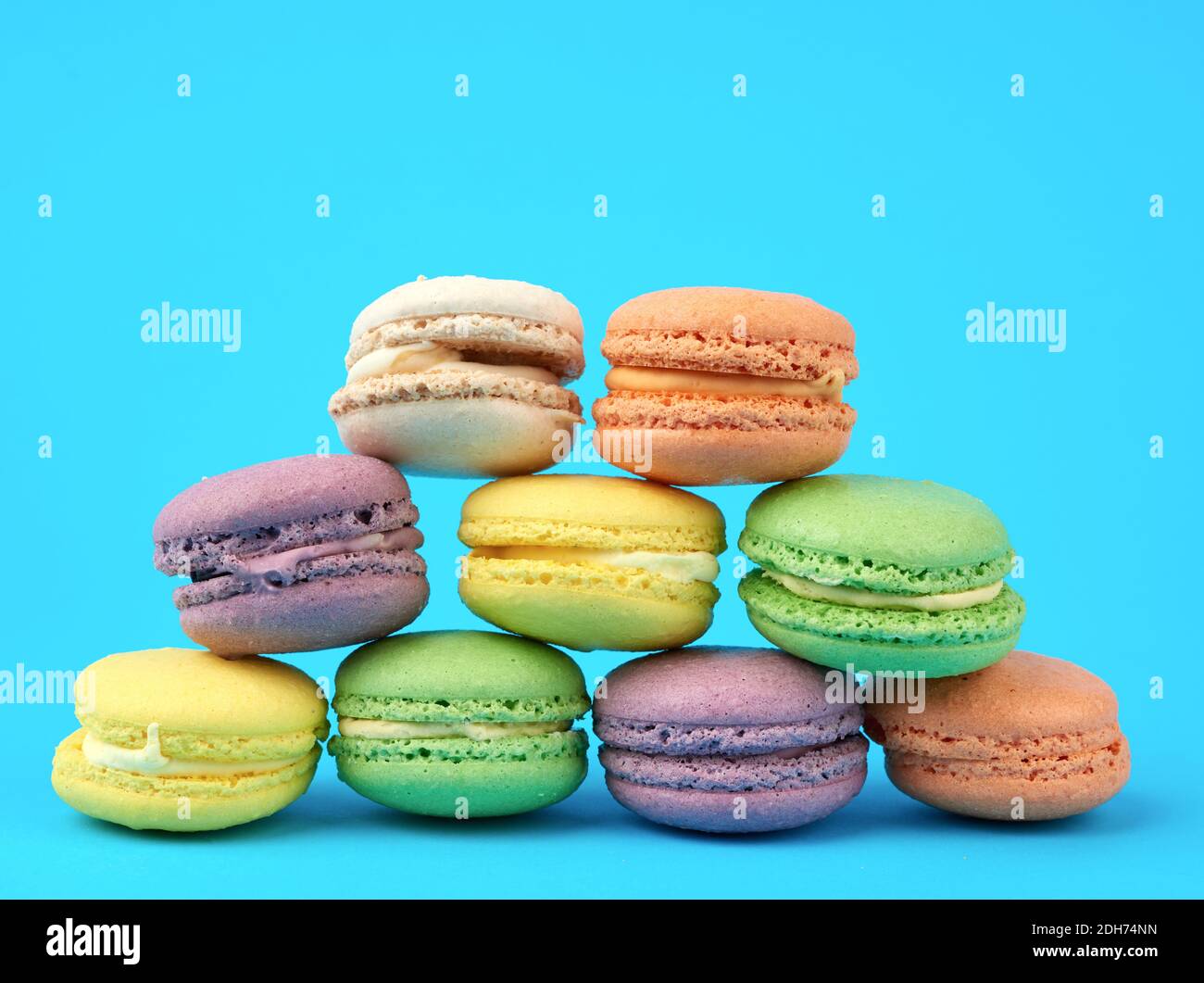 Multi-colored round baked macarons cakes on a light blue background Stock Photo