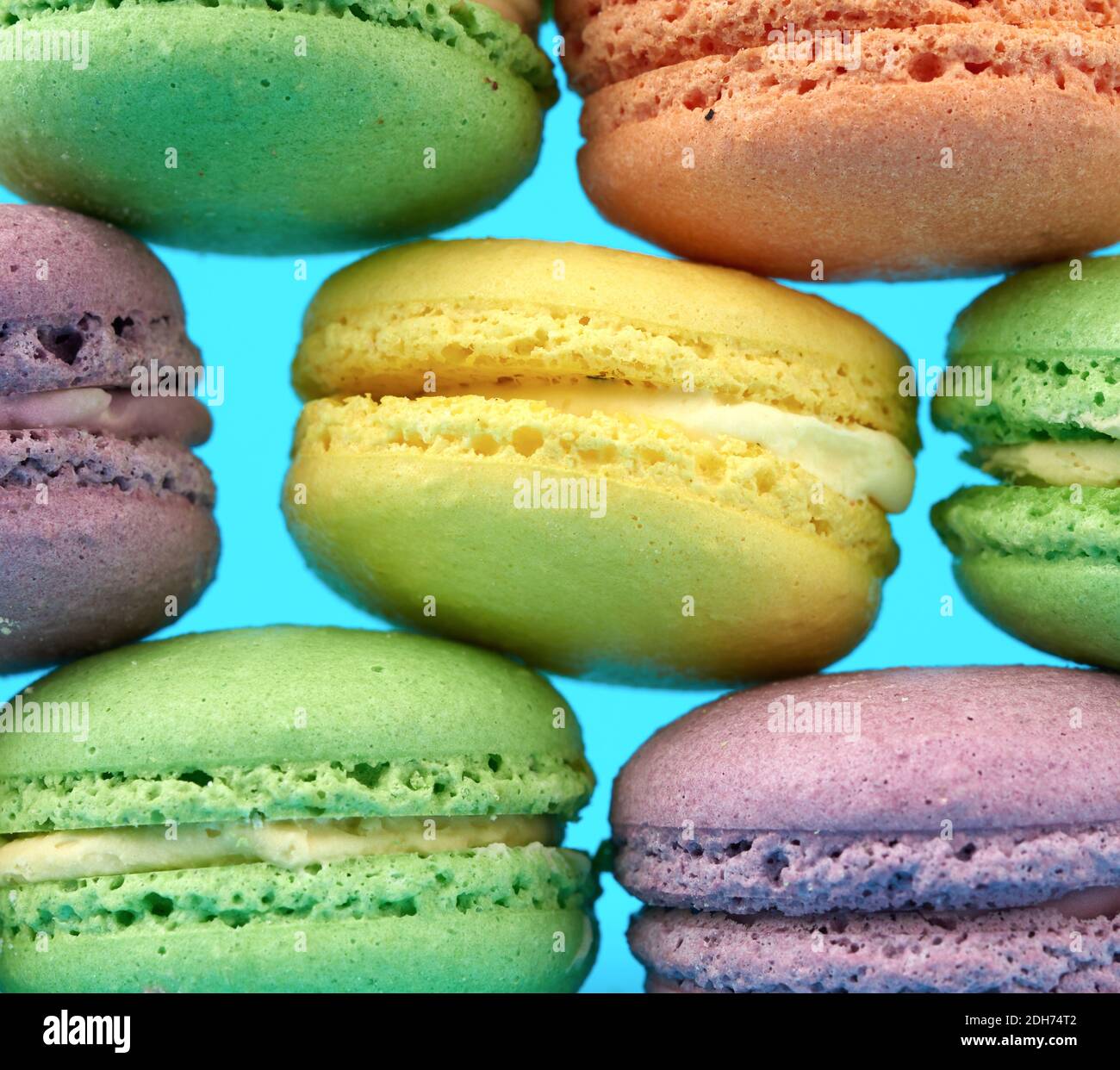 Multi-colored round baked macarons cakes on a light blue background Stock Photo