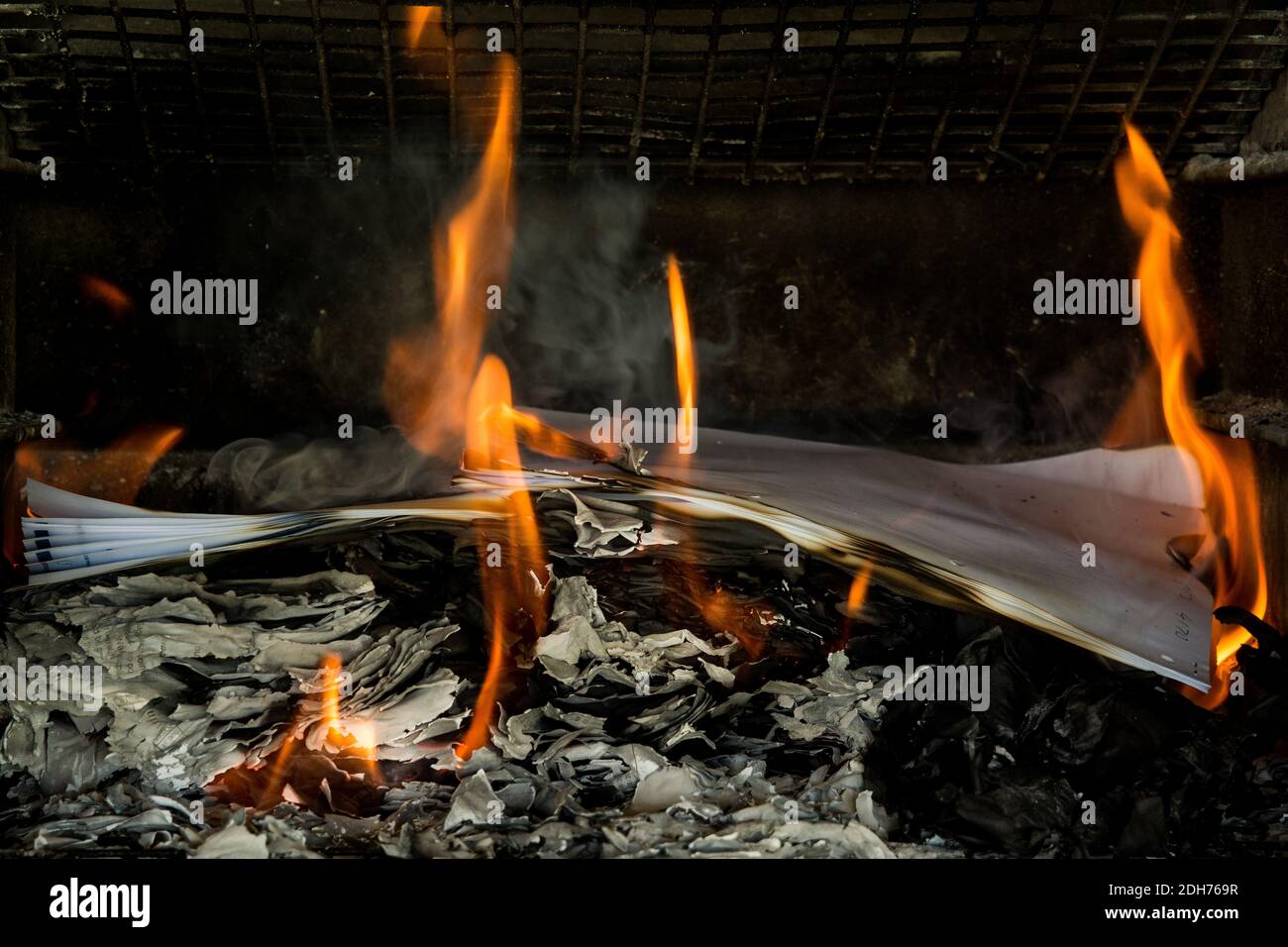 Burning paper documents. Flames and scorched paper. Good example of destroying evidence by burning it. Ashes left behind. Stock Photo