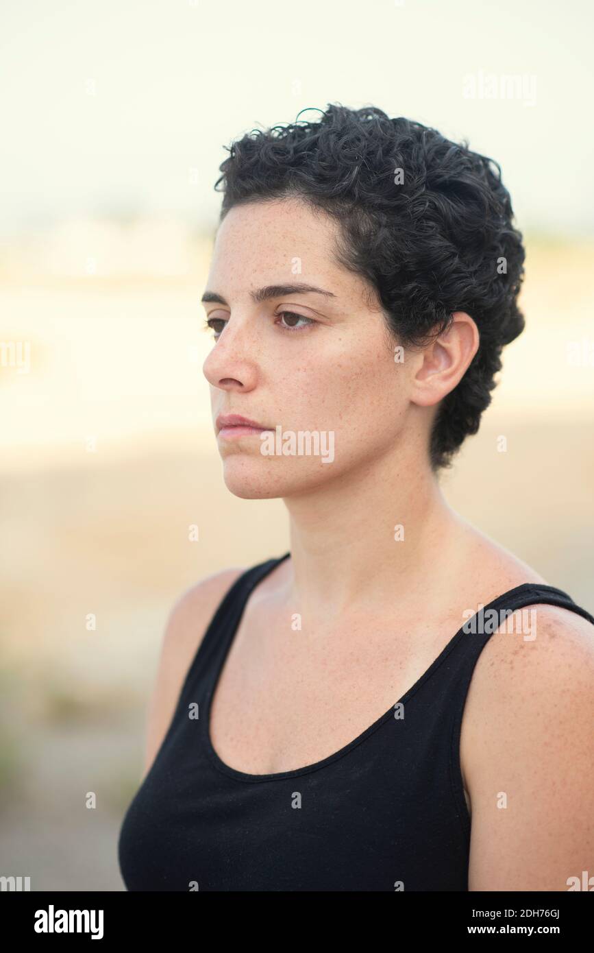 Beautiful young woman with short hair looking away outdoors Stock Photo